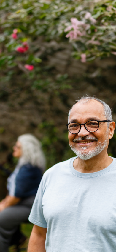 Image d’un homme avec des lunettes qui sourit 